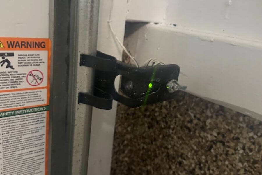 technician installing new garage door sensor