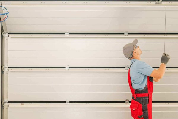 male garage door repairman testing the gate after repair